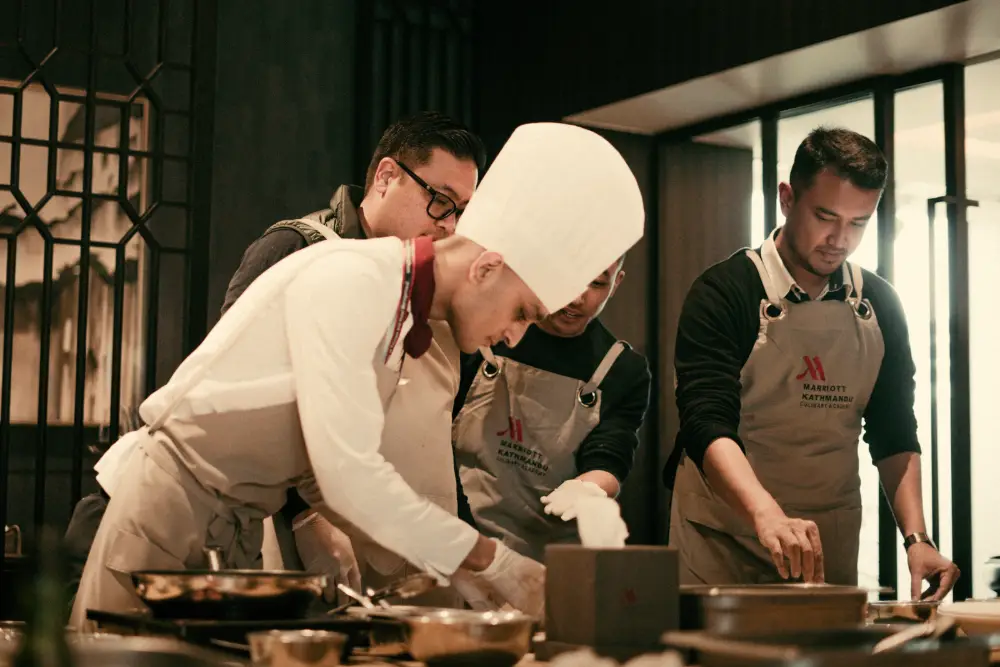 Une brigade de cuisiniers dresse des assiettes pendant le service